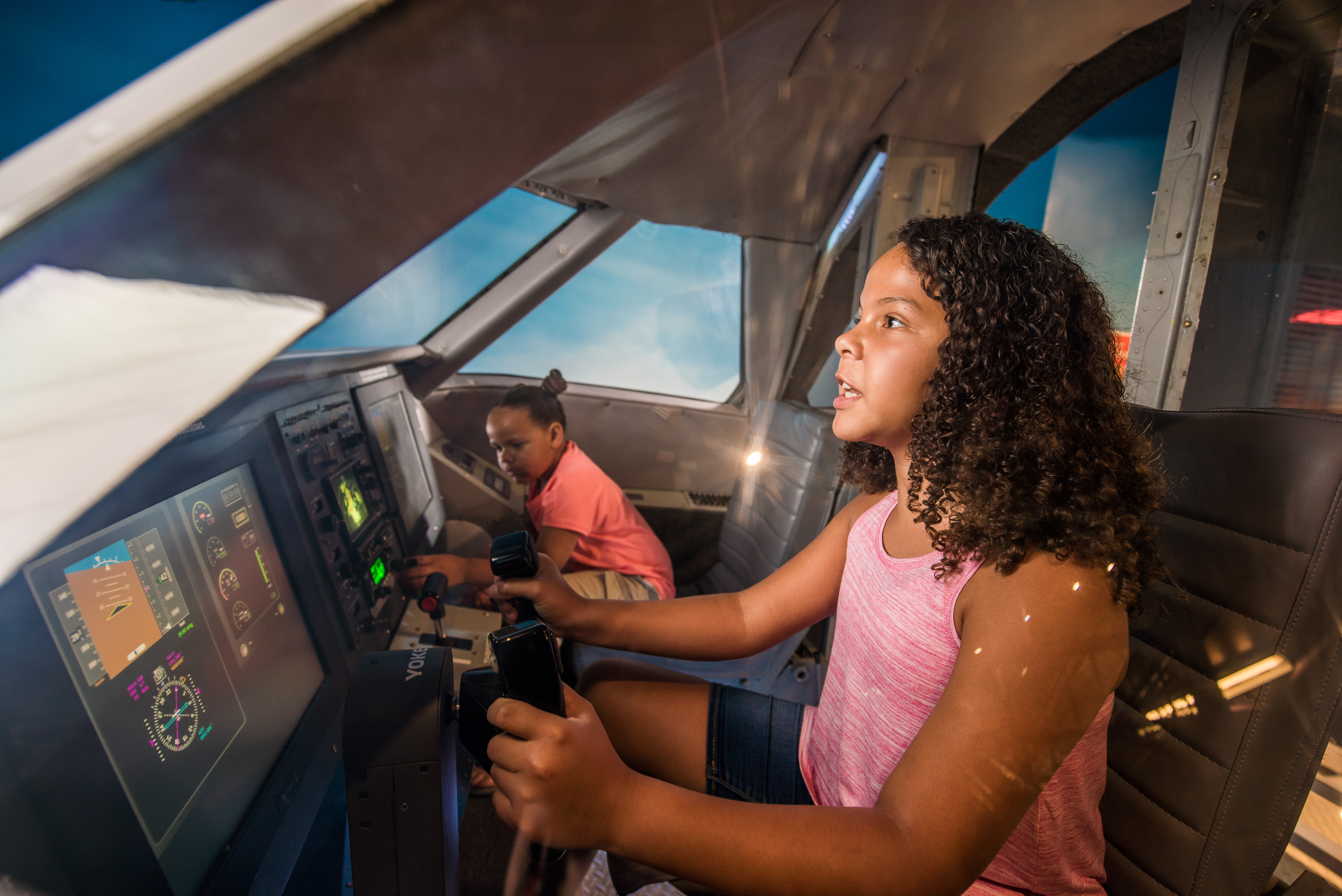 girl steering a plane in the flight simulator